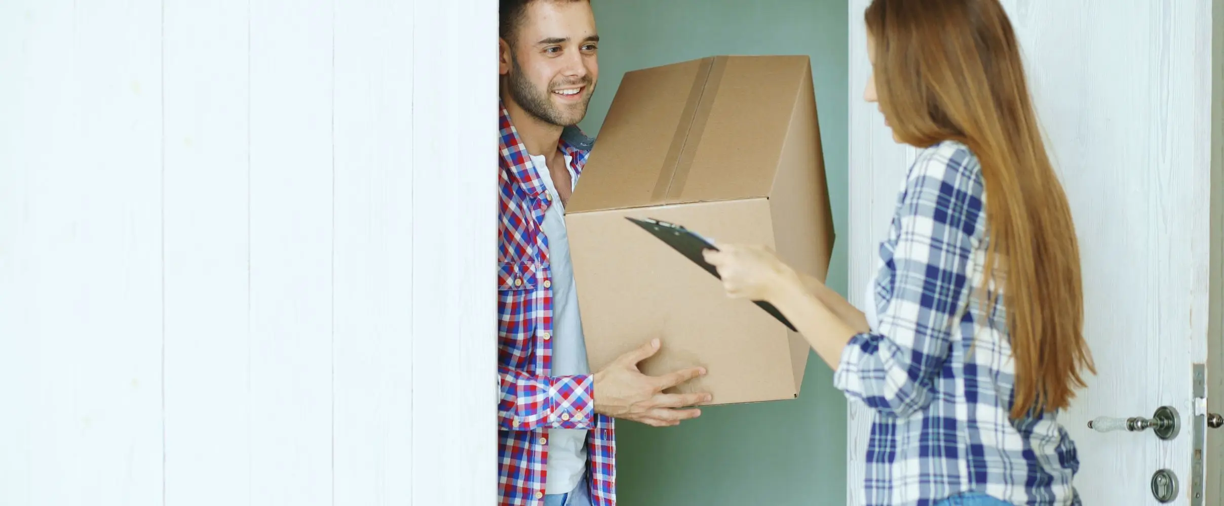 A courier handing a parcel over at the front door