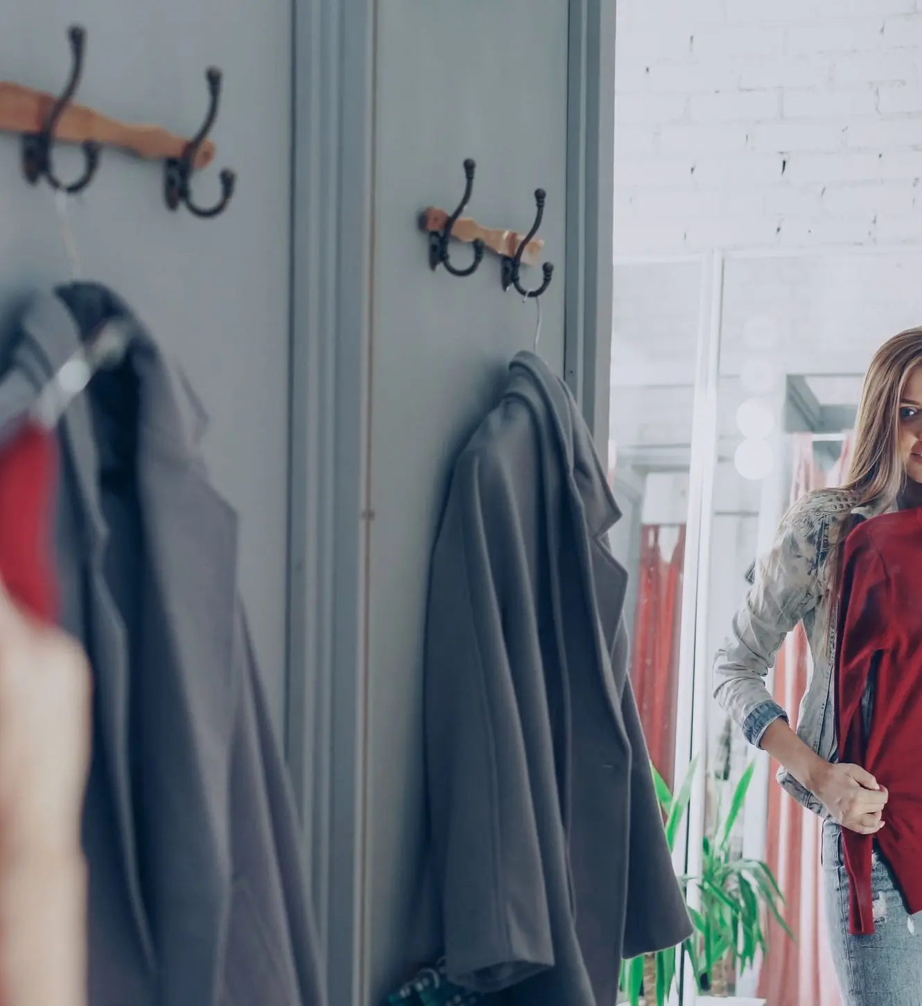 Trying on a red sweater in front of a boutique mirror